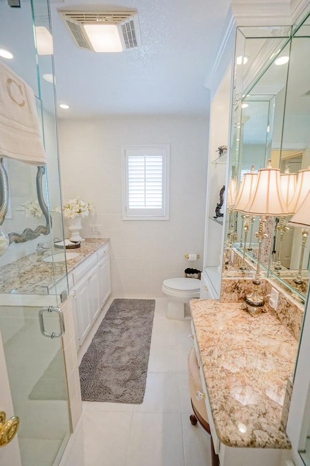 bathroom featuring tile patterned flooring, toilet, vanity, and walk in shower