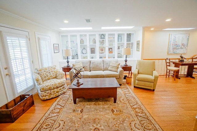 living area with light wood-type flooring and ornamental molding