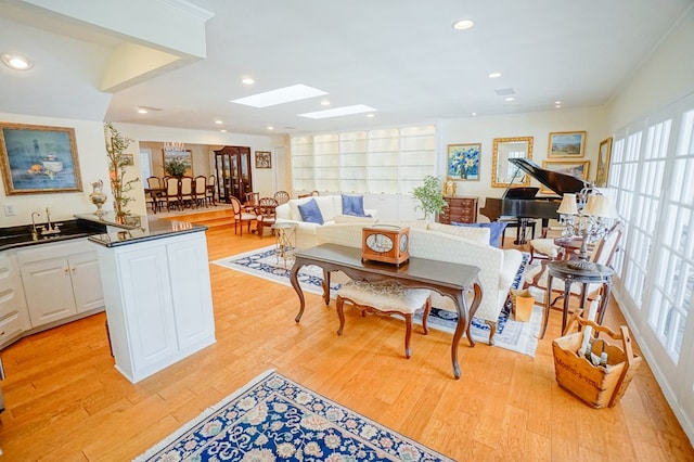 interior space with light wood-type flooring, a skylight, plenty of natural light, and sink