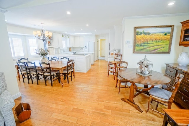 dining area featuring a chandelier, light hardwood / wood-style floors, and ornamental molding