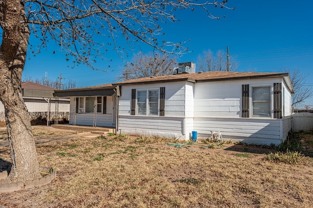 rear view of house featuring a yard