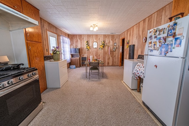 kitchen featuring white refrigerator, gas stove, light carpet, and washer / dryer