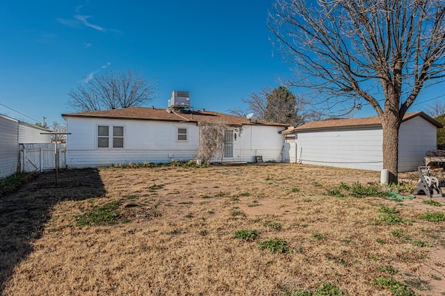 back of house with a yard and central air condition unit