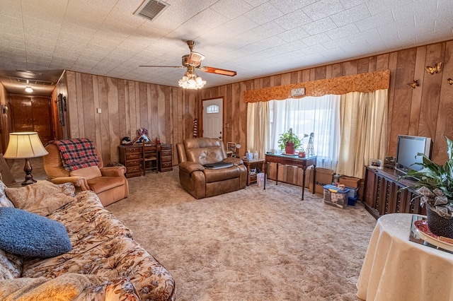 living room with wooden walls, carpet floors, and ceiling fan