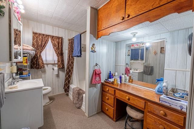 bathroom with walk in shower, wood walls, vanity, and toilet