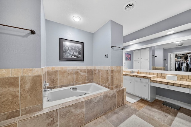 4502 Green Tree Blvd, Midland, TX 79707 - full bath with a garden tub, vanity, a spacious closet, and stone finish floors