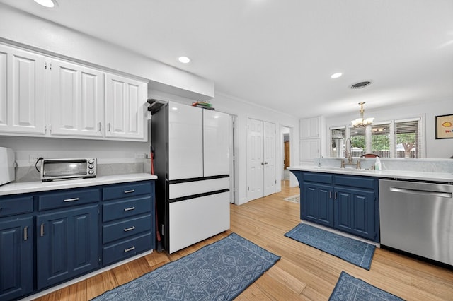 4502 Green Tree Blvd, Midland, TX 79707 - kitchen featuring dishwasher, blue cabinets, freestanding refrigerator, a chandelier, and white cabinets