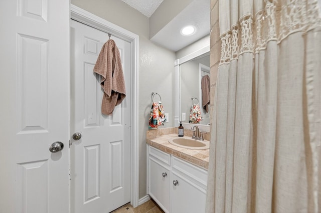 4502 Green Tree Blvd, Midland, TX 79707 - bathroom with vanity, tile patterned flooring, and a textured ceiling