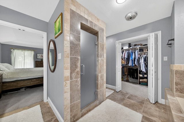 4502 Green Tree Blvd, Midland, TX 79707 - ensuite bathroom featuring a stall shower and a spacious closet