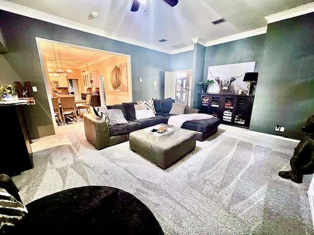 carpeted living room with crown molding, ceiling fan, and visible vents