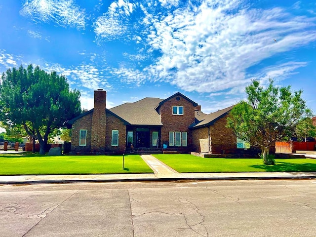traditional home featuring brick siding, a chimney, and a front yard