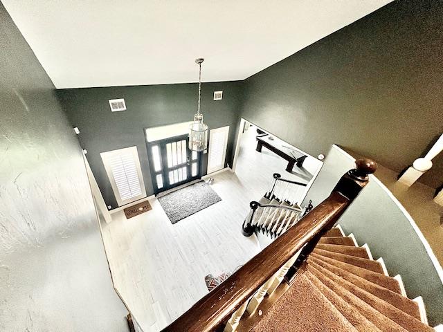stairway featuring wood finished floors and visible vents