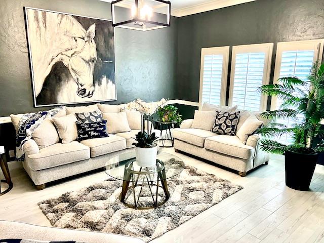 living area with crown molding and wood finished floors