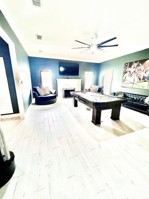 game room with visible vents, wood finished floors, a fireplace, ceiling fan, and pool table