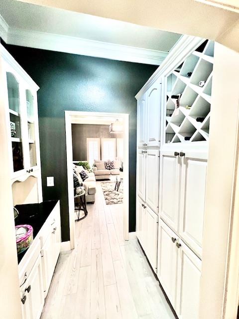 hall with crown molding and light wood finished floors