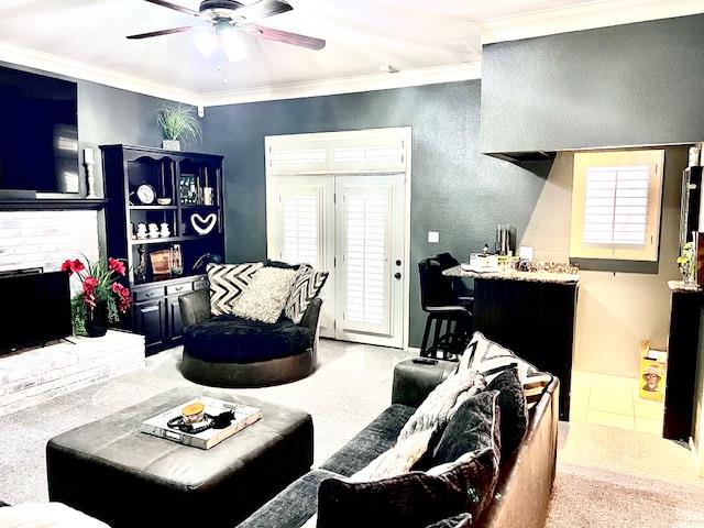 living area with plenty of natural light, crown molding, and ceiling fan