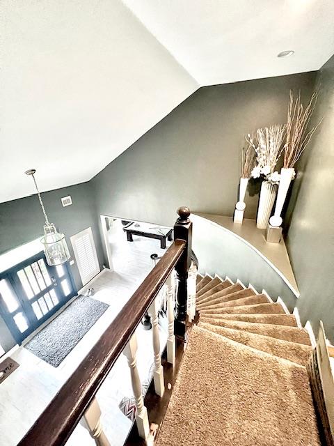 staircase with vaulted ceiling and wood finished floors