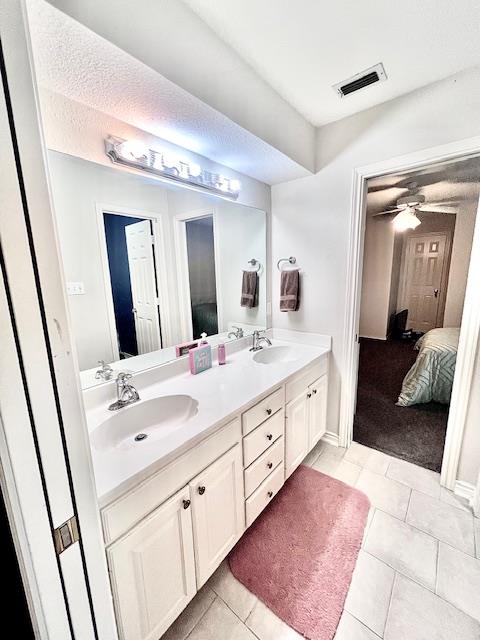 ensuite bathroom featuring double vanity, visible vents, a sink, and ensuite bath