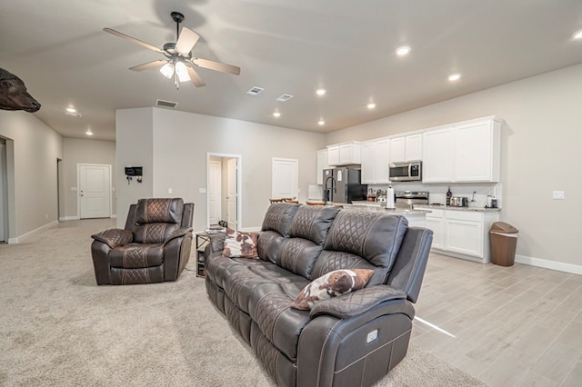 living room with recessed lighting, visible vents, ceiling fan, and baseboards