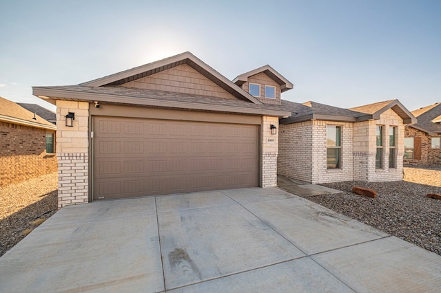 view of front of property featuring brick siding, driveway, an attached garage, and roof with shingles