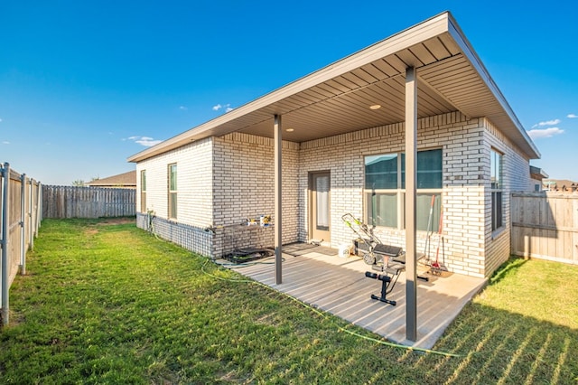 rear view of property with a patio area, a fenced backyard, a lawn, and brick siding