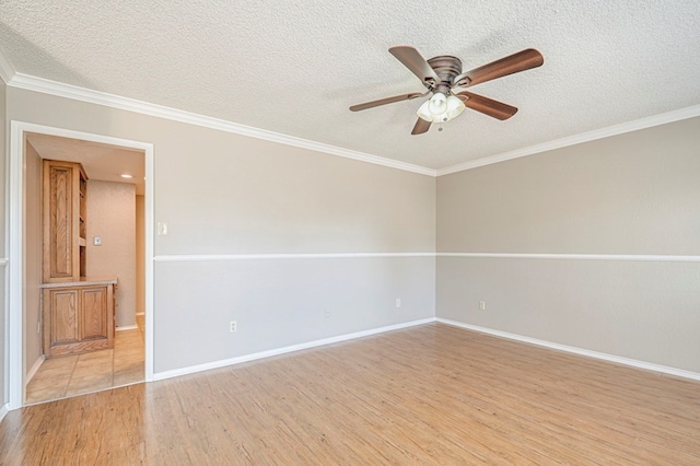 empty room with ornamental molding, ceiling fan, a textured ceiling, and light wood-type flooring