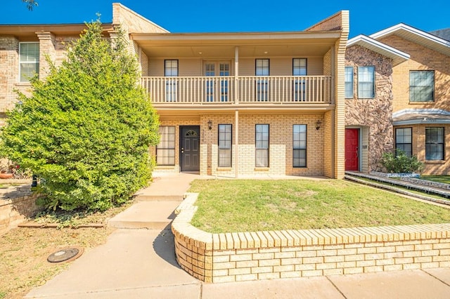 townhome / multi-family property featuring a front lawn and a balcony