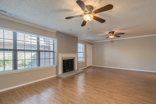 unfurnished living room featuring ornamental molding, a fireplace, hardwood / wood-style floors, and plenty of natural light