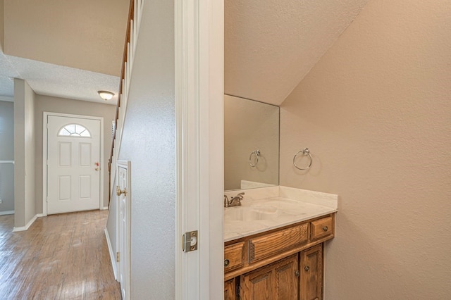 bathroom with hardwood / wood-style flooring, vanity, and a textured ceiling