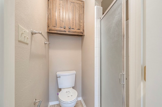 bathroom with a shower with shower door and toilet