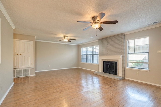 unfurnished living room featuring a wealth of natural light, ornamental molding, and light wood-type flooring