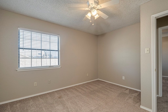 empty room with ceiling fan, light colored carpet, and a textured ceiling