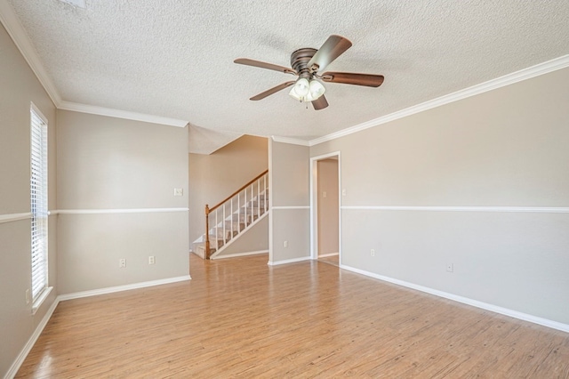 empty room featuring crown molding, light hardwood / wood-style floors, and a textured ceiling