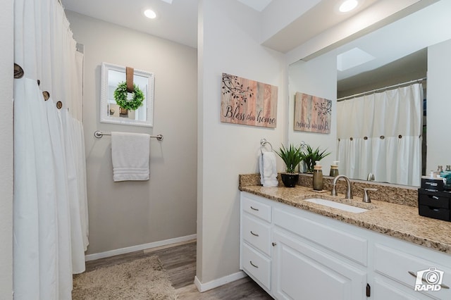 4313 Downing Ave, Midland, TX 79707 - bathroom featuring vanity, wood finished floors, baseboards, and recessed lighting