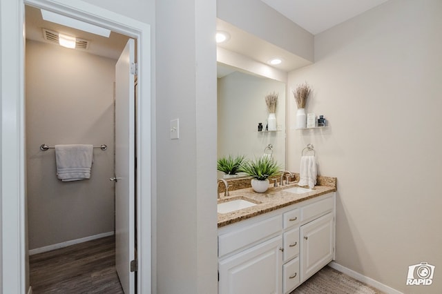 4313 Downing Ave, Midland, TX 79707 - bathroom with double vanity, wood finished floors, and baseboards