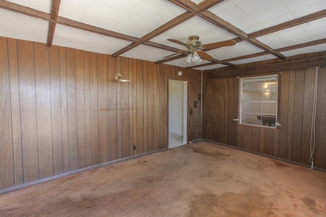 carpeted empty room with wooden walls, beamed ceiling, coffered ceiling, and ceiling fan