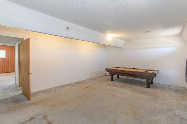 basement with light colored carpet, a textured ceiling, and billiards