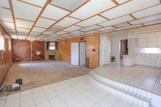 interior space featuring wooden walls and a brick fireplace