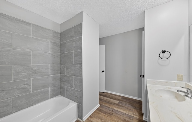 3208 Preston Dr, Midland, TX 79707 - bathroom with wood finished floors, vanity, a textured ceiling, and shower / washtub combination