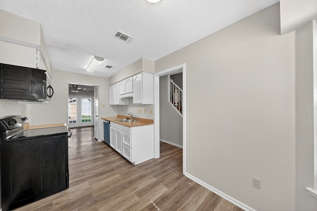 3208 Preston Dr, Midland, TX 79707 - kitchen with black appliances, ceiling fan, wood finished floors, white cabinetry, and light countertops