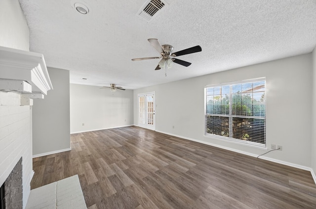 3208 Preston Dr, Midland, TX 79707 - unfurnished living room with a fireplace, a ceiling fan, a textured ceiling, and wood finished floors
