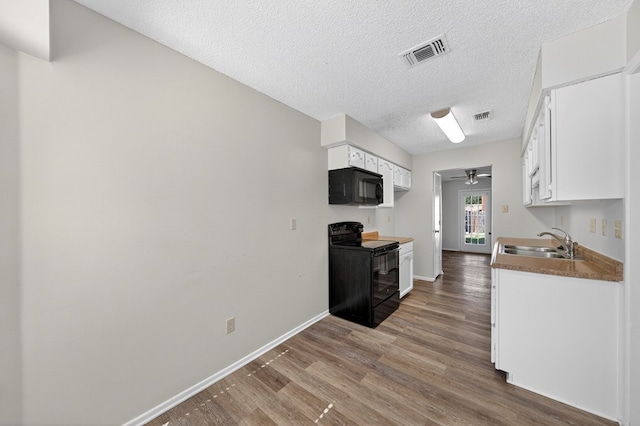 3208 Preston Dr, Midland, TX 79707 - kitchen with black appliances, wood finished floors, white cabinetry, a ceiling fan, and a textured ceiling