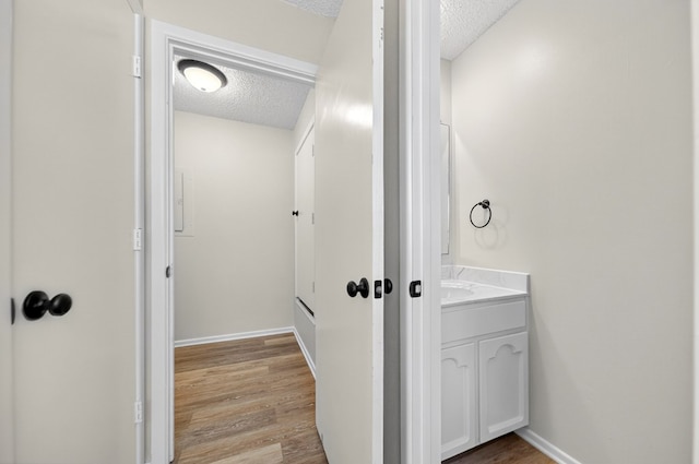 3208 Preston Dr, Midland, TX 79707 - bathroom featuring a textured ceiling, vanity, and wood finished floors