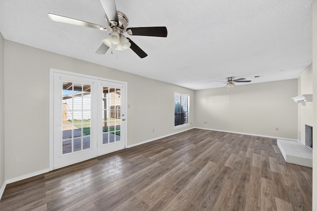 3208 Preston Dr, Midland, TX 79707 - unfurnished living room with ceiling fan, wood finished floors, a brick fireplace, and a textured ceiling