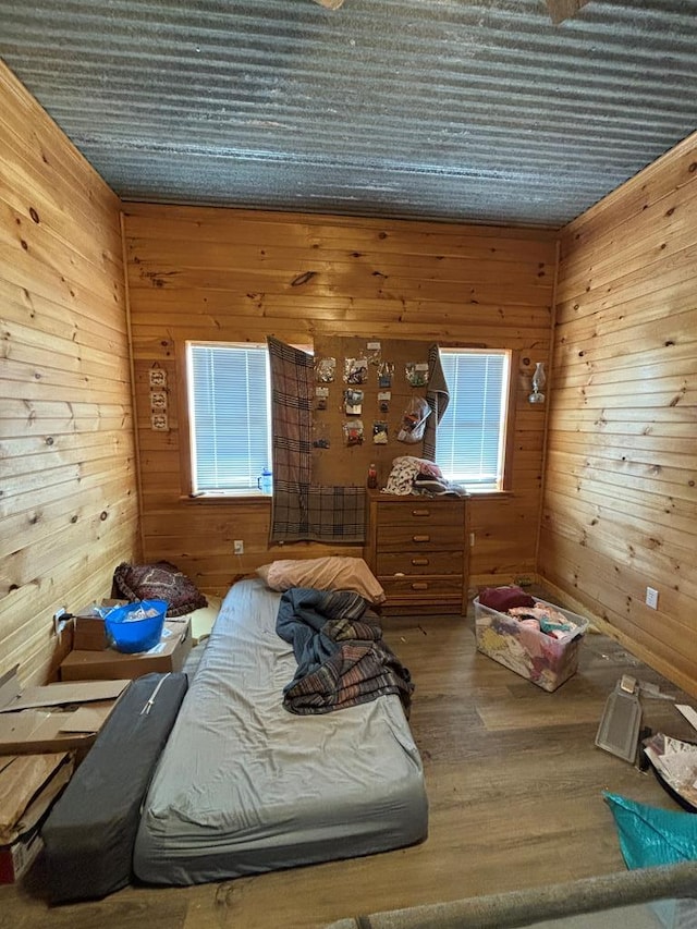 unfurnished bedroom with wood walls and wood finished floors