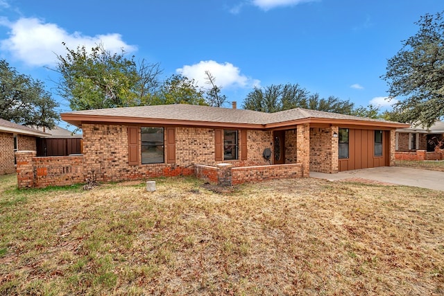 single story home featuring a patio area, brick siding, board and batten siding, and a front yard