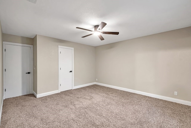 unfurnished bedroom featuring carpet, a ceiling fan, and baseboards