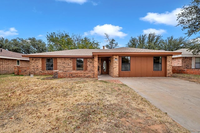 single story home featuring board and batten siding, brick siding, and a front lawn