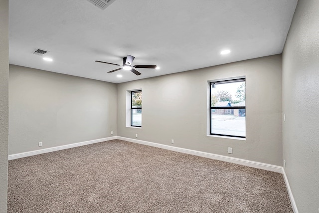 unfurnished room featuring baseboards, carpet floors, visible vents, and a healthy amount of sunlight