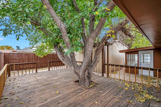 wooden deck with a fenced backyard